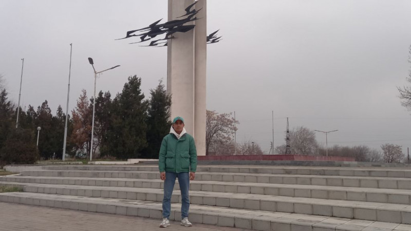 Фото: Жанабай Исраилов на фоне символа города Чирчик - памятника "Журавли", воздвигнутого в память о погибших в ВОВ