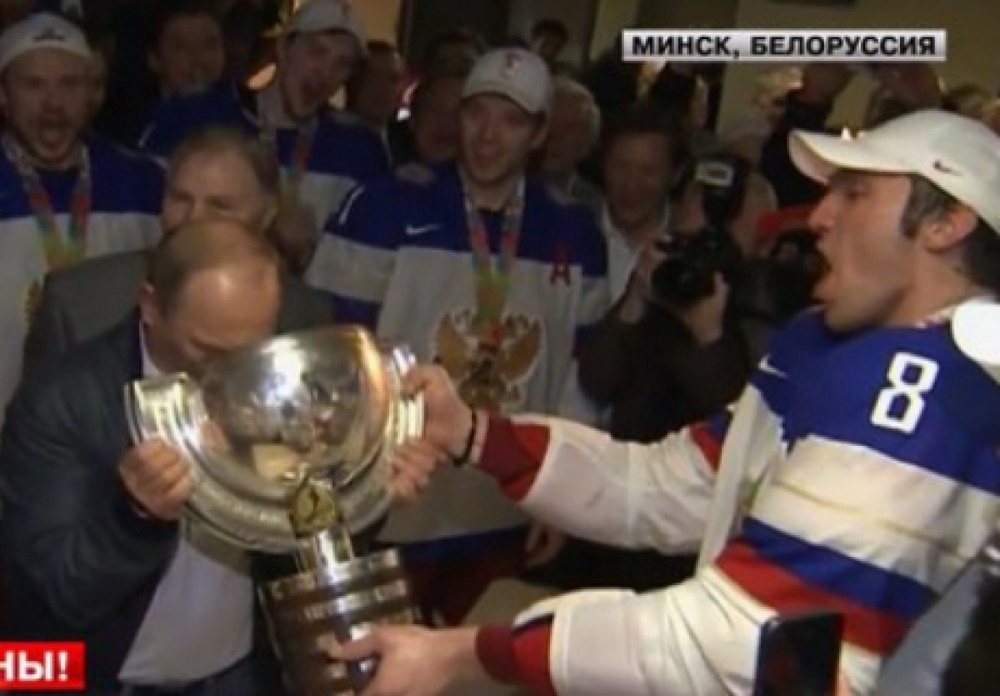 Владимир Путин пьет из чемпионского кубка. Скриншот с телеканала Lifenews
