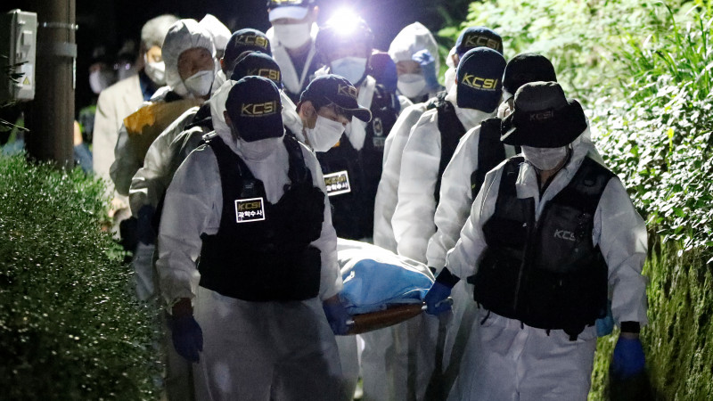 Полицейские несут тело мэра Сеула. © Reuters