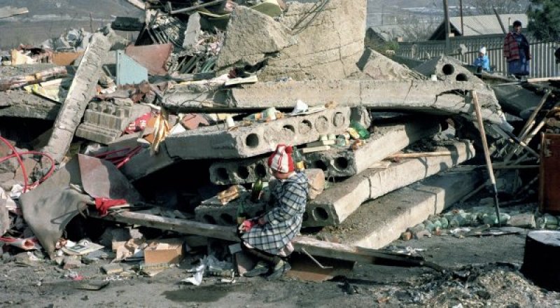 Ребенок сидит на развалинах родного дома, разрушенного в результате землетрясения. Армения, декабрь 1988 года. © РИА Новости